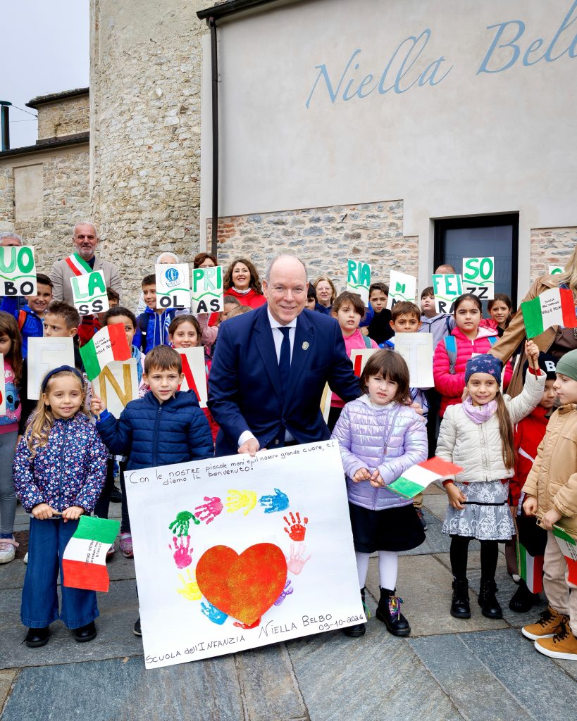 Prince Albert II of Monaco surrounded by cheering schoolchildren holding welcome signs and Italian flags in Niella Belbo, Italy, on October 9, 2026