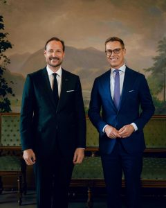 King Haakon of Norway receiving Finland's President Alexander Stubb in audience at the Royal Palace in Oslo, with a painted Norwegian landscape mural behind them